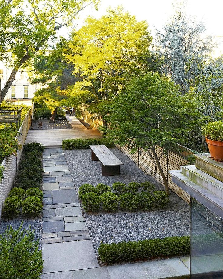 a very nice looking garden with some benches and trees in it's back yard