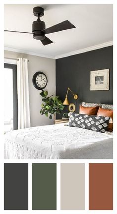 a bedroom with black walls, white bedding and a ceiling fan in the corner