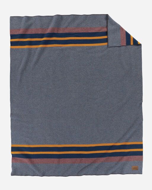 the blue and yellow striped blanket is folded on top of a white surface with an orange stripe