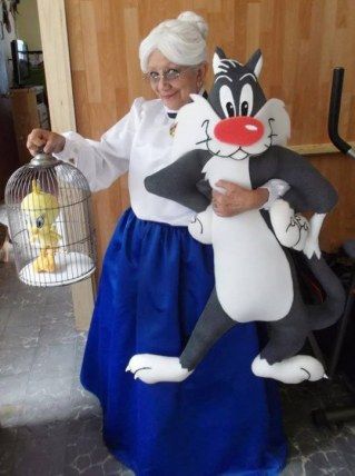 an older woman is holding a large stuffed cat