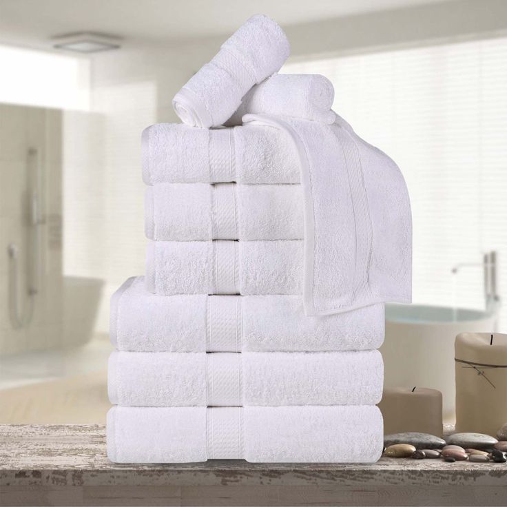 a stack of white towels sitting on top of a counter