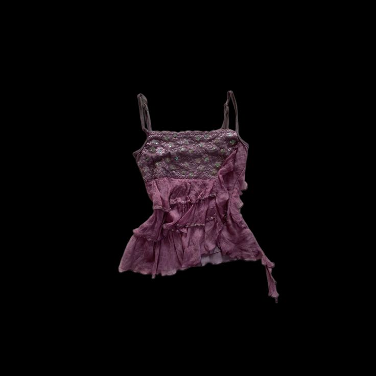 a pink dress hanging on a clothesline against a black background, with the bottom part of it ruffled