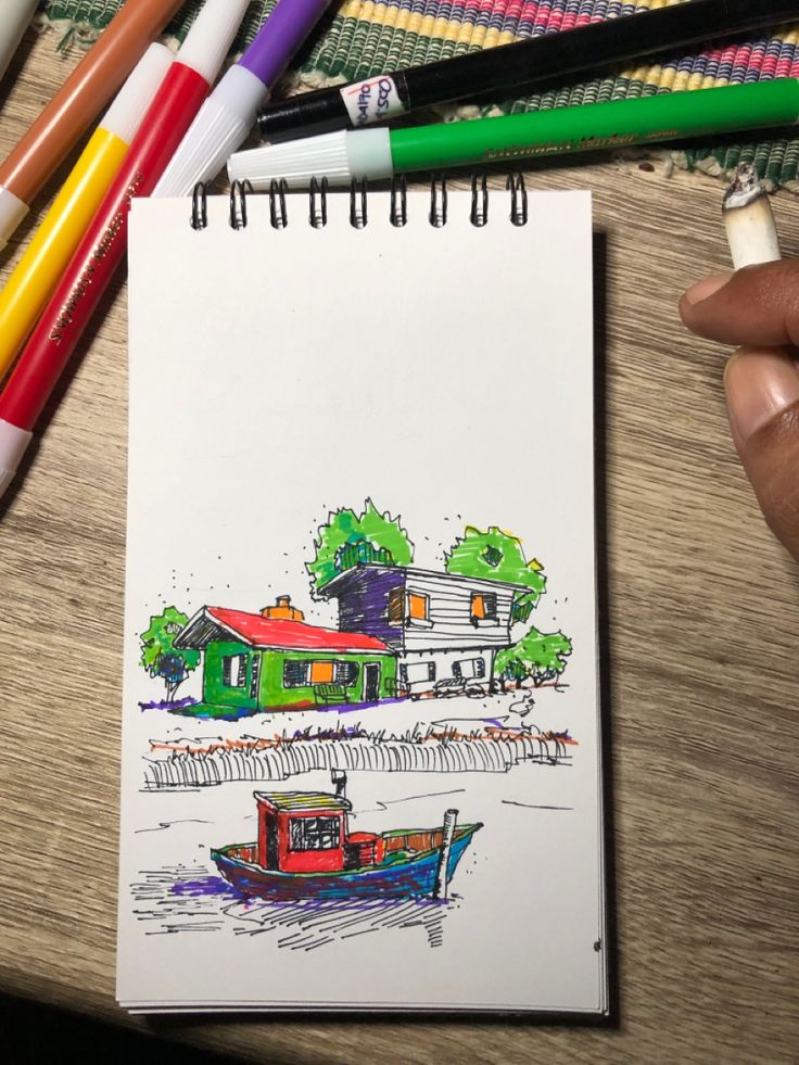 a drawing of a boat in the water next to some colored pencils