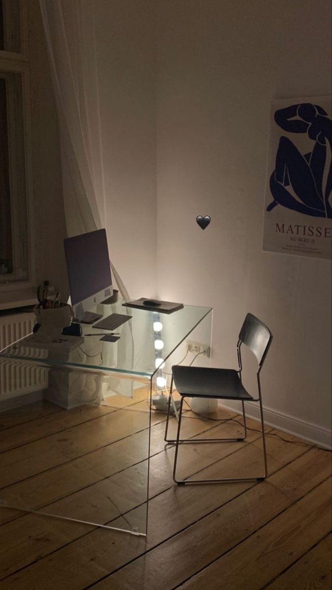 a glass table with two chairs in front of it and a lamp on the floor