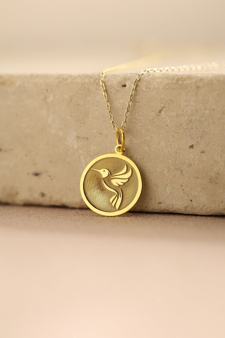 Gold Hummingbird Pendant - Hummingbird Gold Necklace ● Material of pendant: Solid Gold 14k ( REAL GOLD ) ● Metal Stamp: 14k ( REAL GOLD ) ● The pendant is available in 5 sizes: - 12,7 mm / 0.5 inches (Diameter) - 14,0 mm / 0,55 inches ( Diameter ) In the photos - 15,3 mm / 0.6 inches ( Diameter ) - 16,5 mm / 0,65 inches ( Diameter ) - 19,1 mm / 0,75 inches ( Diameter ) ( In the photos the size is 14mm / 0.55 inches Diameter ) ( Jump Ring inner diameter: 4 mm ) ● Material of chain: Solid gold 14k Round Necklace With Bird Design For Gift, Bird Design Necklace Gift, Gold Round Jewelry With Bird Design, Gift Jewelry With Bird Design Round Pendant, Round Pendant Jewelry With Bird Design For Gift, Bird Design Round Pendant Jewelry As Gift, Bird Design Round Pendant Jewelry For Gifts, Bird Design Round Pendant Jewelry Gift, Necklace With Round Pendant And Bird Design For Gifts