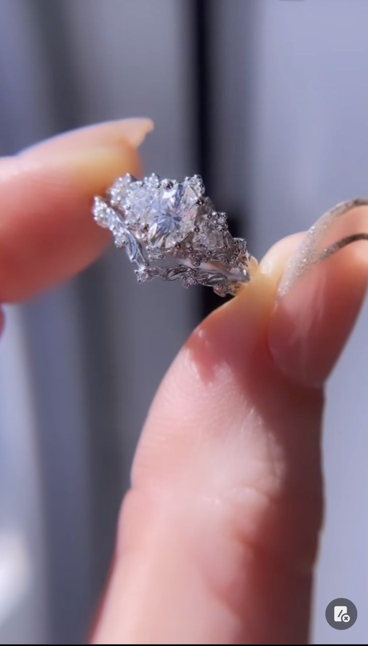 a woman's hand holding a diamond ring