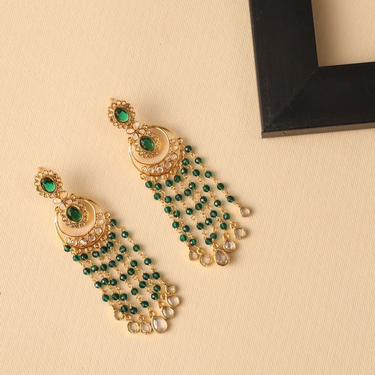 Description : These classic chandbali earrings from Tarinika are a masterpiece with a simple yet stunning style. They display polki stones with a gold-plated base. The beaded chain drops and the minimal design make it sophisticated and rich. Details & Specifications: Materials used: Brass Alloy with Yellow Gold Plating Weight - Earrings 19.62 gm Length - Earrings 8 cm Make it custom Want to make it a custom earring? Sure! Reach out to us at support@tarinika.com and we’ll be happy to make possibl Elegant Stone Work Danglers For Diwali, Elegant Kundan Danglers For Celebration, Elegant Meenakari Chandelier Earrings For Eid, Elegant Stone Work Chandbalis For Diwali, Elegant Chandbalis With Cutdana For Diwali, Elegant Kundan Jeweled Chandelier Earrings, Festive Elegant Dangling Bead Earrings, Festive Elegant Earrings With Dangling Beads, Elegant Chandelier Earrings For Eid