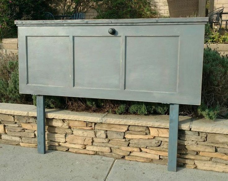 a large gray cabinet sitting on top of a stone wall