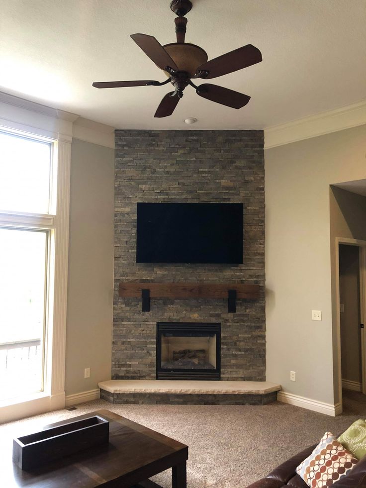 a living room with a couch, fireplace and flat screen tv mounted on the wall