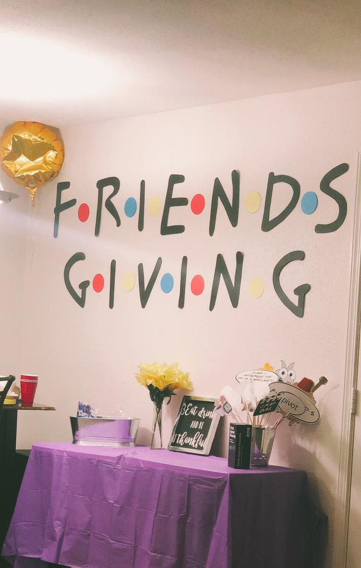 a purple table topped with flowers next to a sign that says friends giving on it