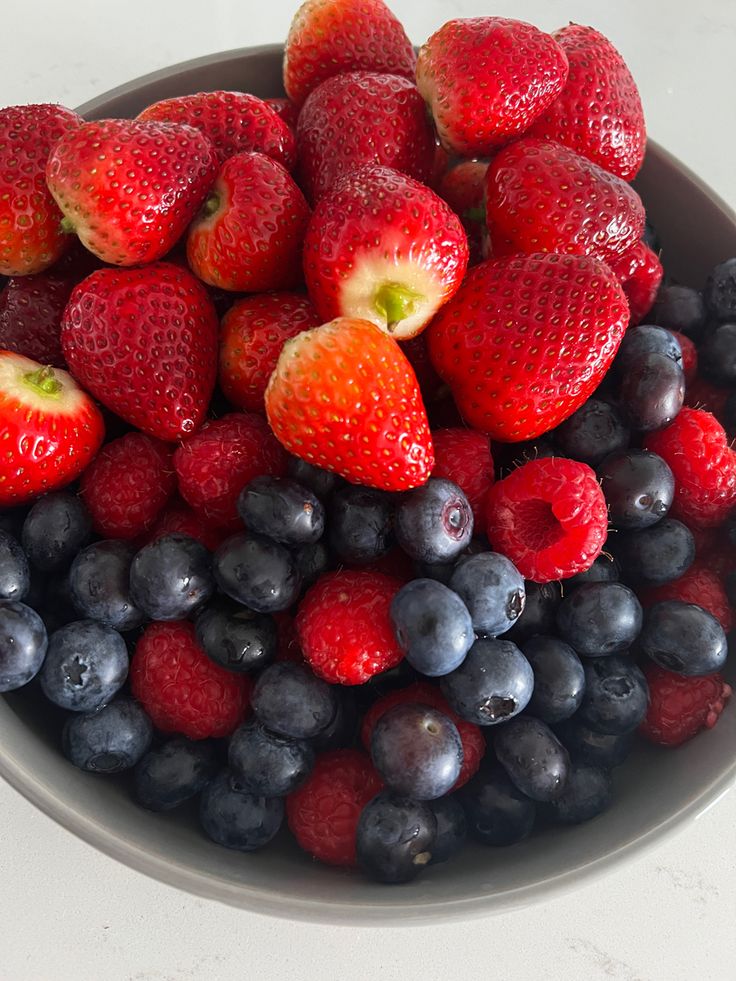 berries and blueberries in a bowl on a table