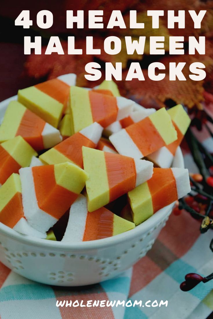 a white bowl filled with halloween snacks sitting on top of a checkered table cloth