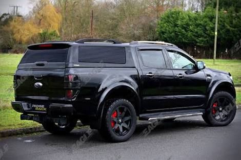 the black truck is parked on the side of the road