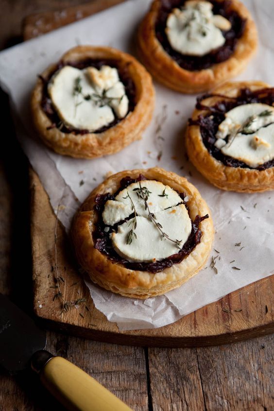 four small pastries are sitting on a cutting board