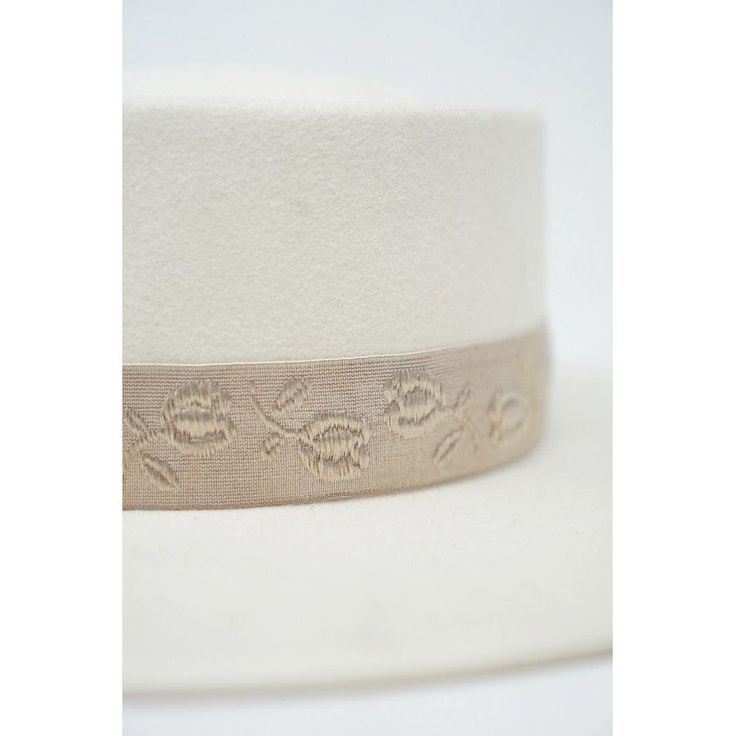 a white hat with an embroidered ribbon around the brim