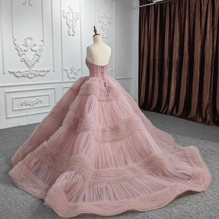 a pink dress on display in front of a white wall