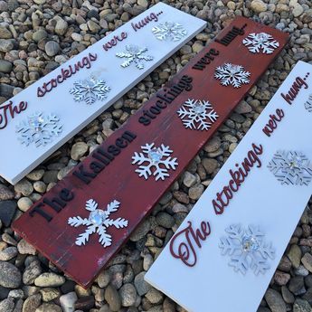 three snowflake signs sitting on top of some rocks