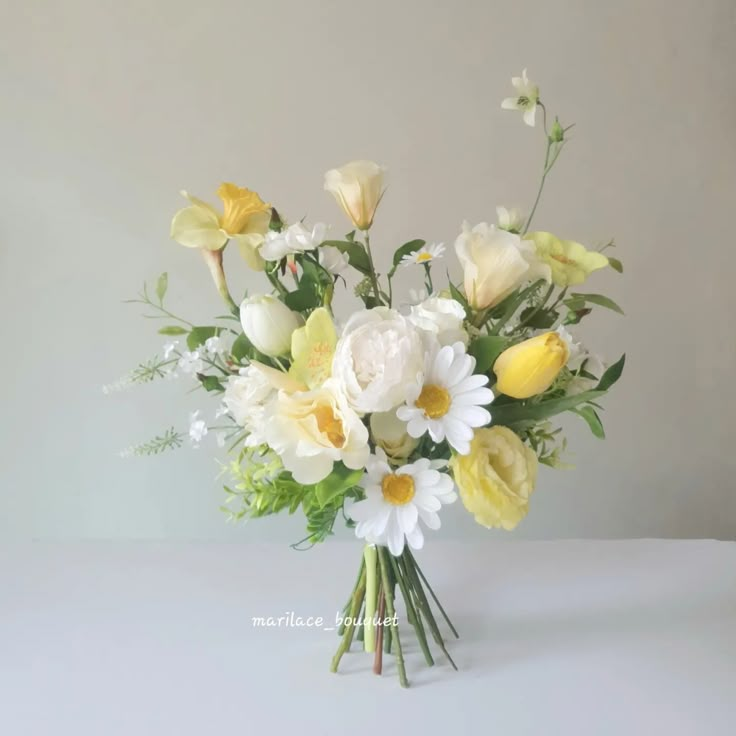 a vase filled with yellow and white flowers