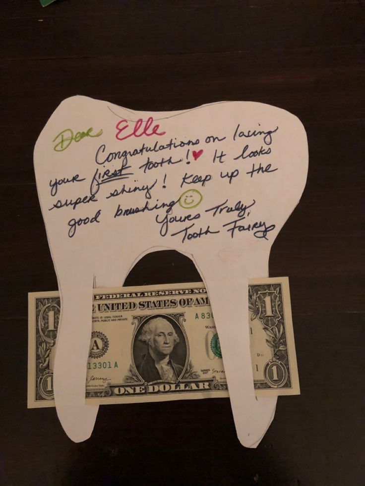 a tooth shaped like a dollar bill with writing on it