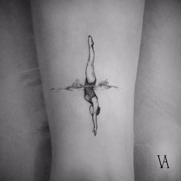 a woman's leg with a tattoo on it that has a swimmer in the water