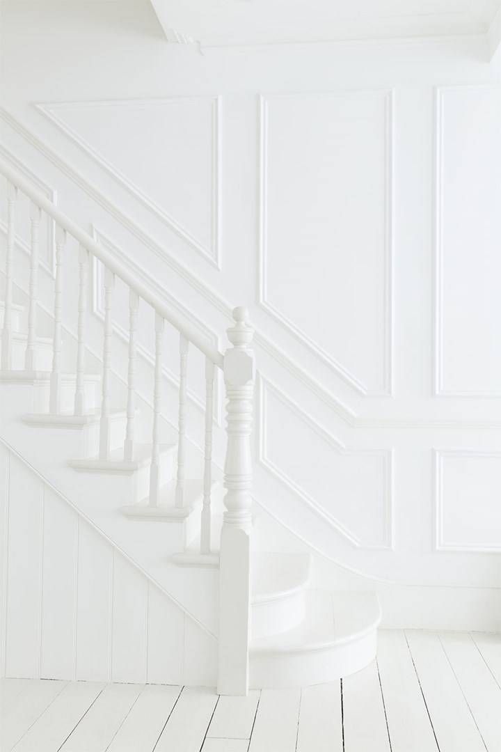 an empty room with white walls and stairs