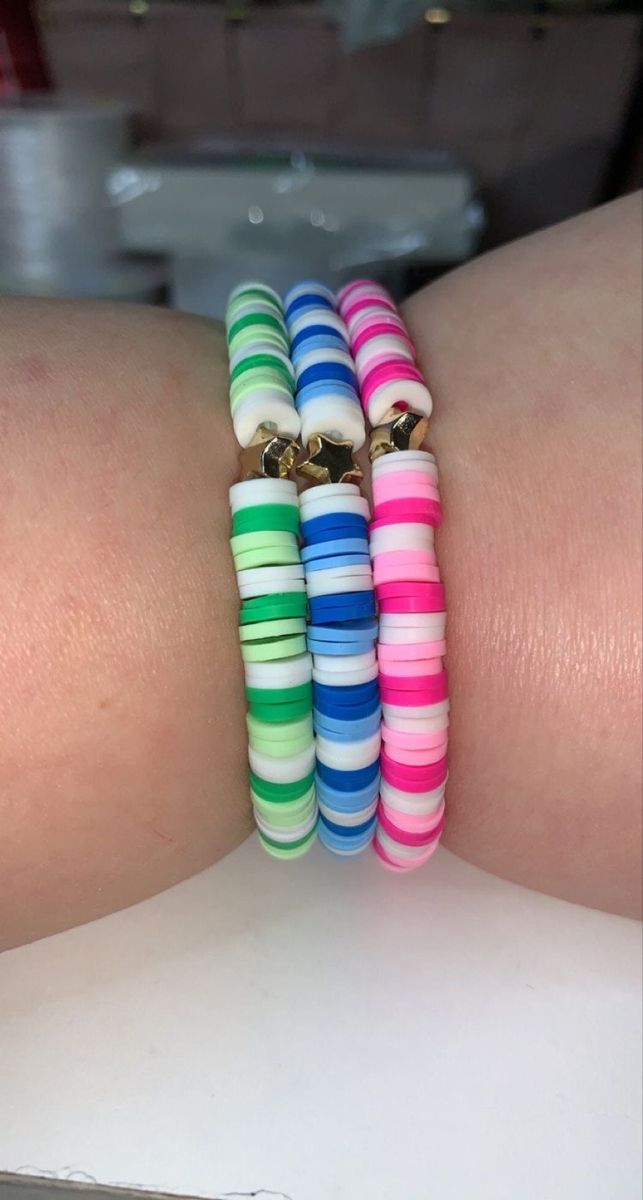 three different colored bracelets on someone's arm