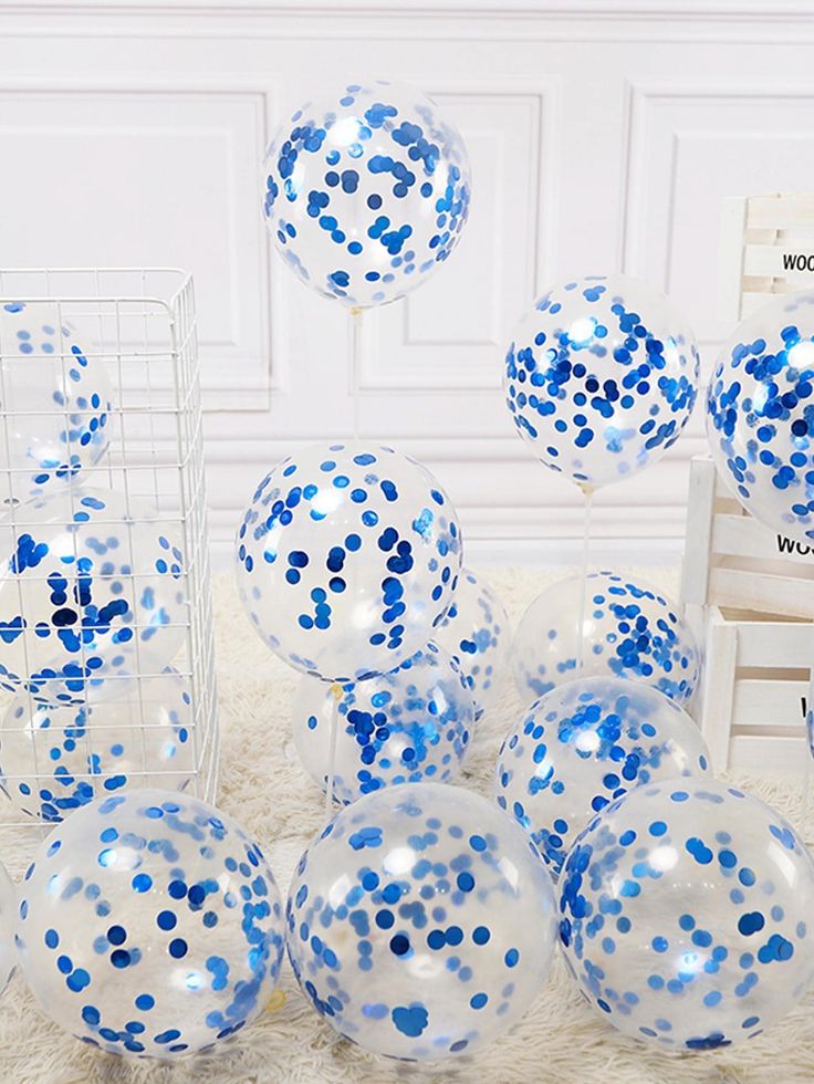 blue and white confetti balloons are on the floor