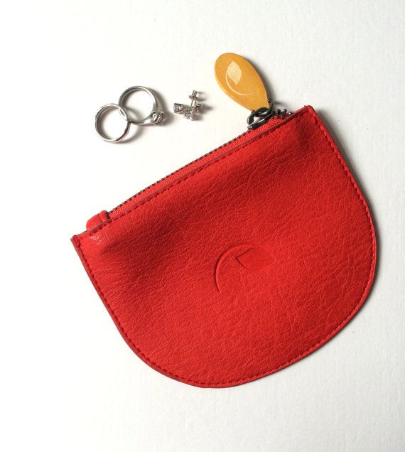 a small red pouch with a pair of scissors on the side and a keychain attached to it