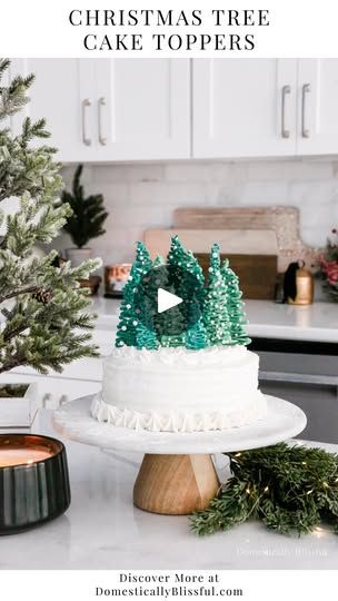 a christmas tree cake topper on a kitchen counter with pine trees in the background