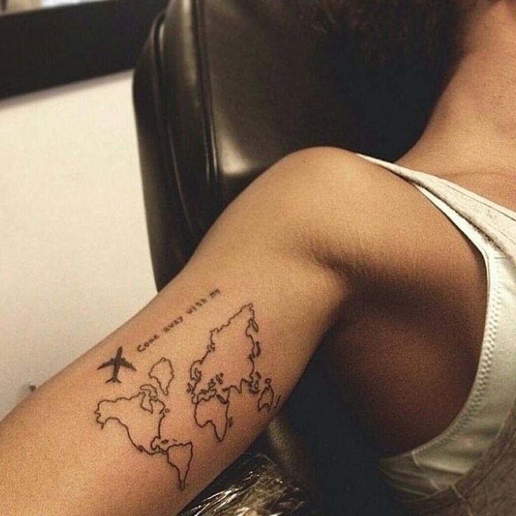 a person with a tattoo on their arm that has an airplane flying over the world