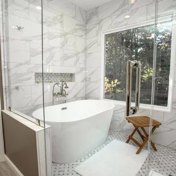 a white bath tub sitting inside of a bathroom next to a walk - in shower