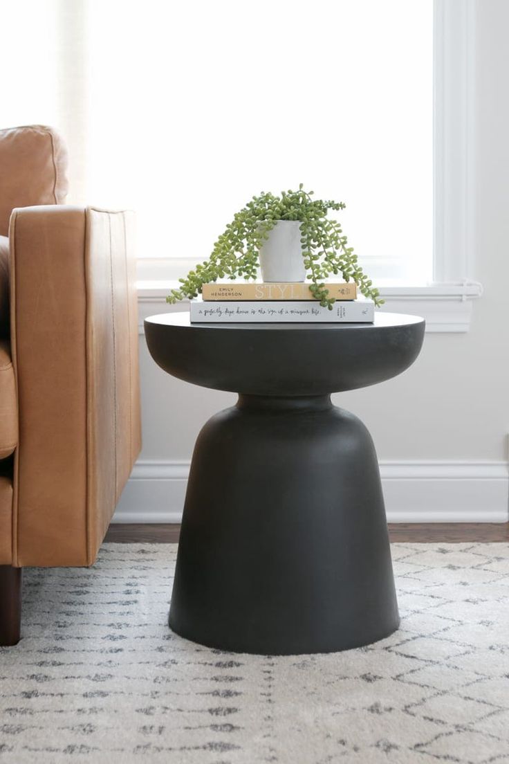 a living room with a chair, table and plant on it's end table