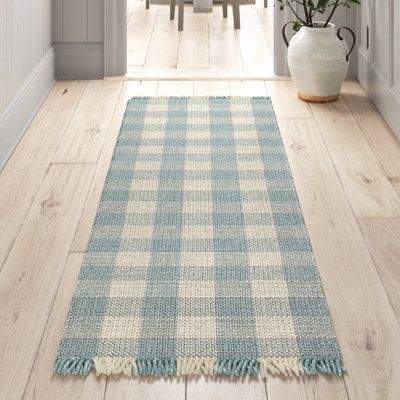 a blue and white checkered rug on the floor in front of a dining room table