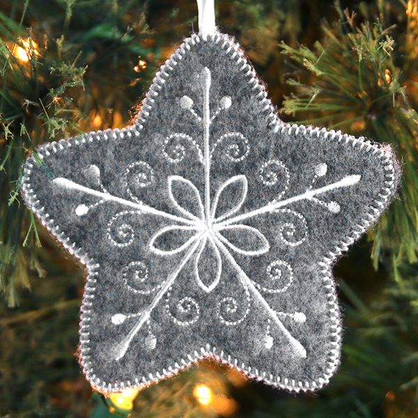 an ornament hanging from a christmas tree decorated with white and gray ornaments,