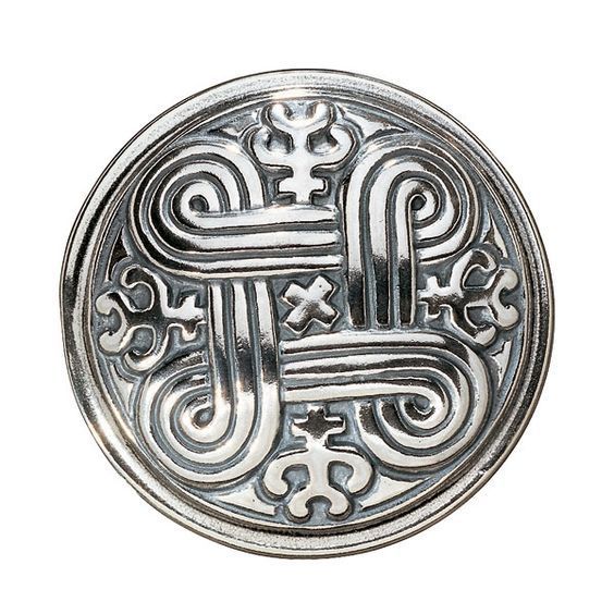 a metal button with an ornate design on it