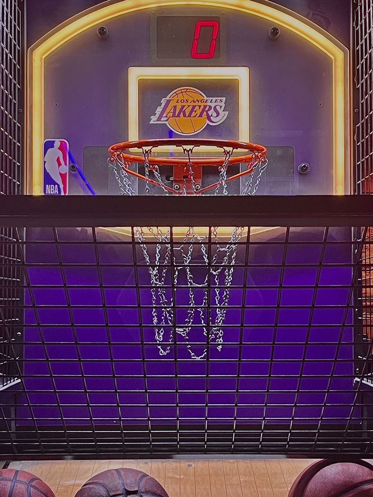 several basketballs are sitting on the floor in front of a basket