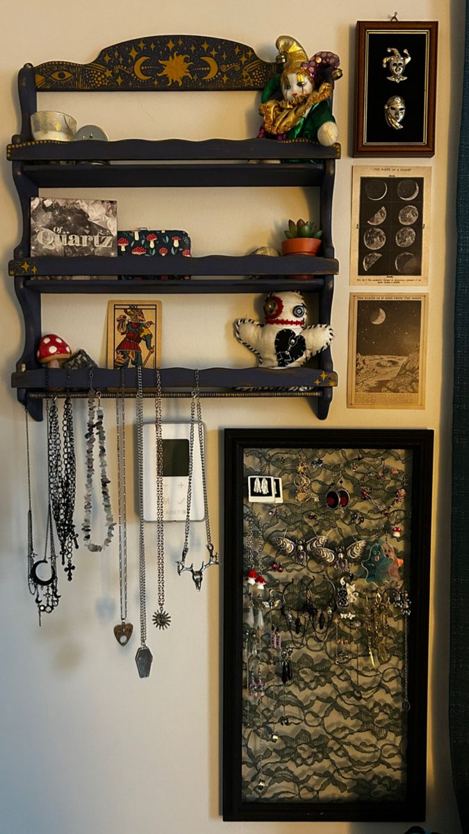 there are many items on the wall and hanging from the shelf above them, including necklaces