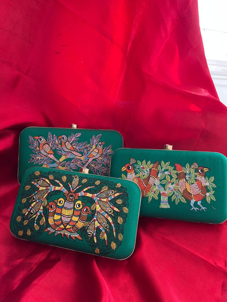 Immerse yourself in a verdant oasis with our enchanting green Gond Art clutch bags. Each piece is a canvas of nature's splendor, meticulously hand-painted with intricate designs inspired by the graceful peacock, lively sparrows, and a harmonious symphony of birds amidst lush trees. Unleash your inner art connoisseur with these dreamlike accessories, perfect for elevating your evening ensemble. Gond Art, a timeless tradition from Madhya Pradesh, India, breathes life into our clutches through its Artistic Green Rectangular Shoulder Bag, Green Hand-painted Bag As Gift, Green Hand Painted Bags For Gift, Artistic Green Shoulder Bag As Gift, Hand Painted Green Bags For Gift, Green Hand Painted Rectangular Shoulder Bag, Hand Painted Green Rectangular Shoulder Bag, Green Hand Painted Rectangular Bag, Green Hand Painted Rectangular Bags