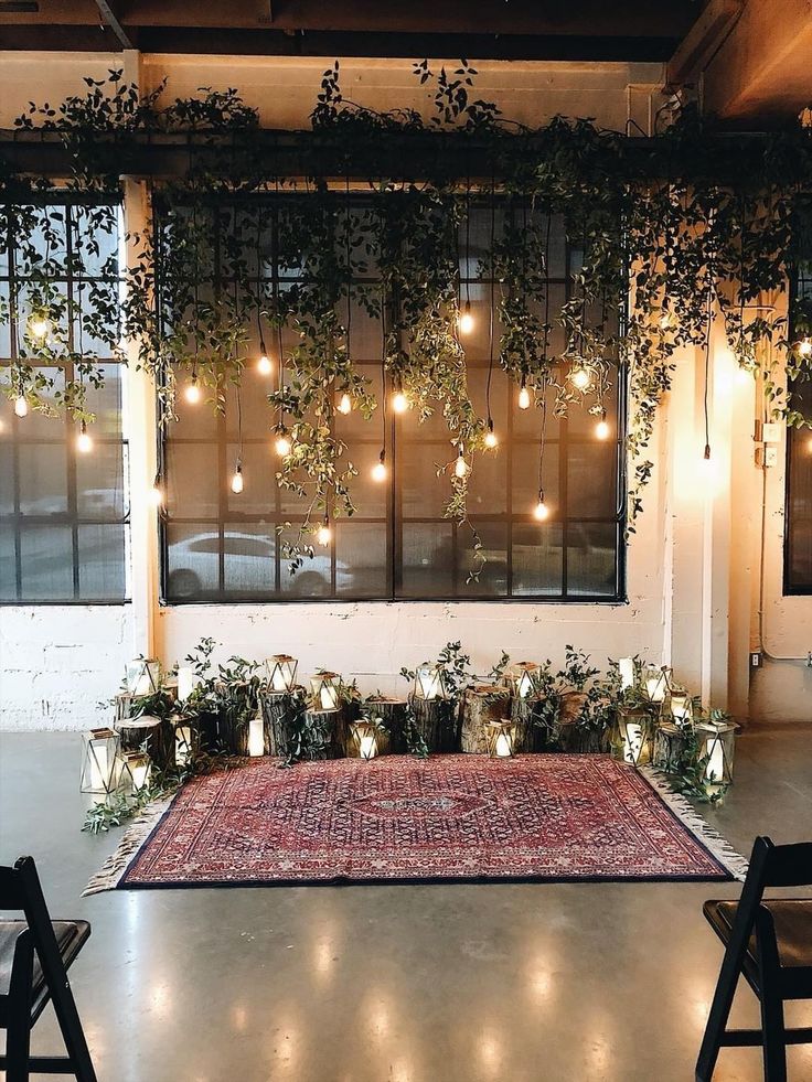 an indoor area with plants and lights on the windowsill, in front of a large rug