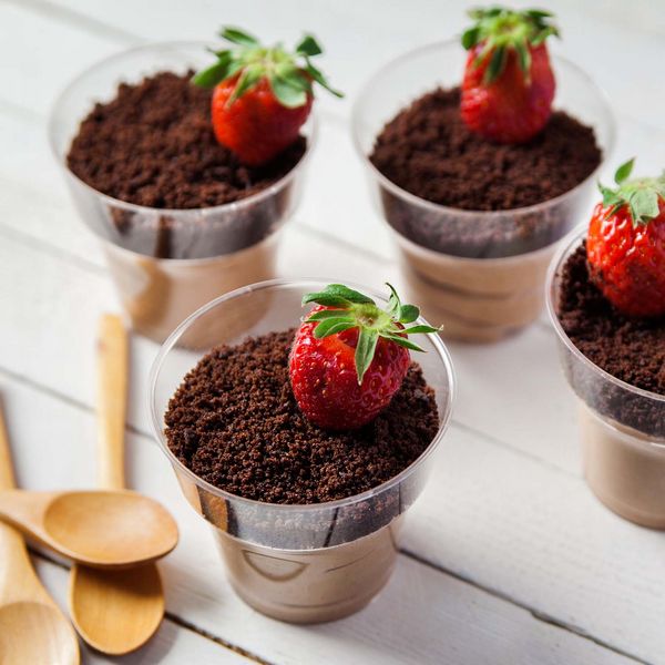 four dessert cups filled with chocolate pudding and strawberries