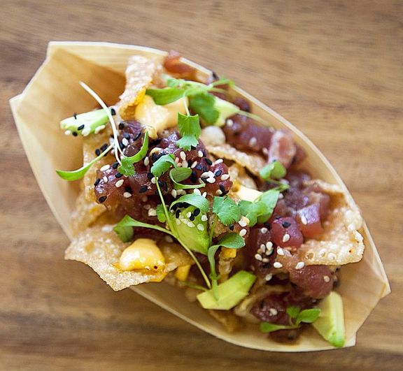 a taco filled with meat and veggies on top of a wooden table