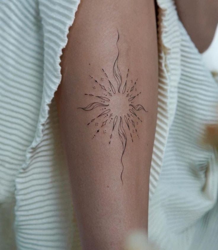 a woman's arm with a tattoo on it that has a flower in the center