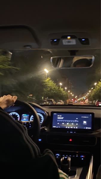 a man driving a car at night in the city