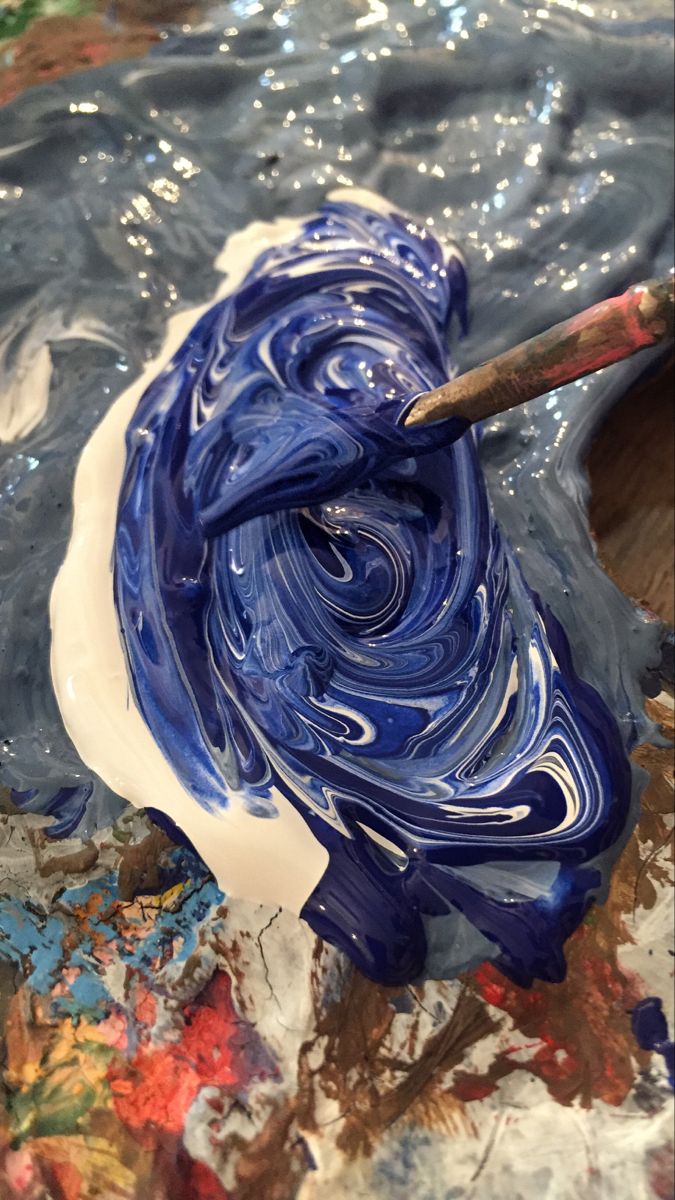 a blue and white swirl is being used to paint an abstract painting with acrylic paints