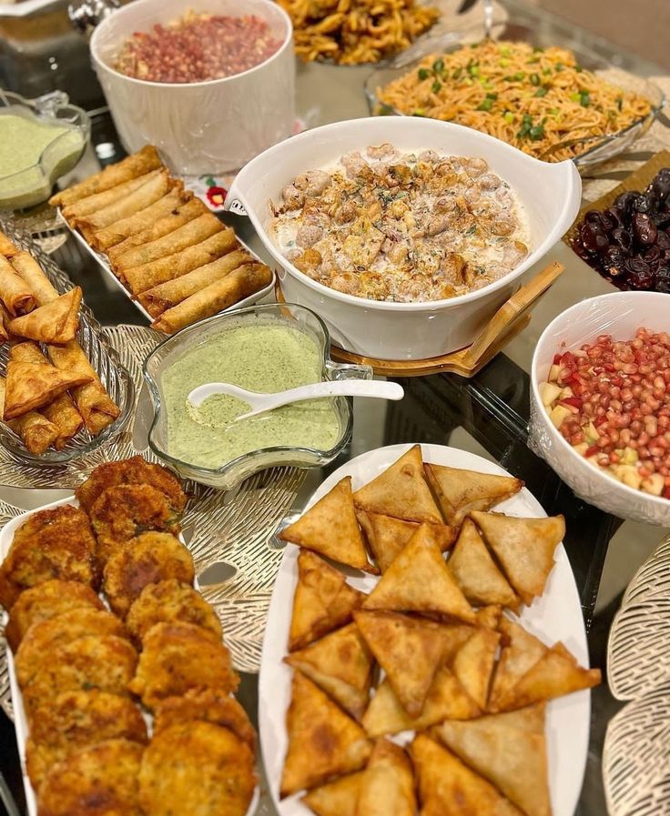 a table filled with lots of different types of food and dipping sauces on top of it