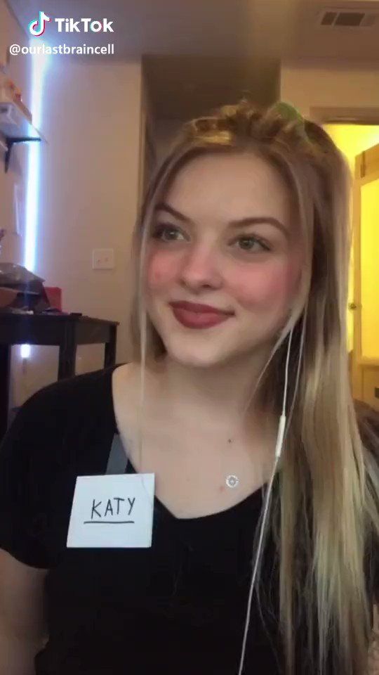 a woman with headphones on is smiling at the camera and has her name tag attached to her ear