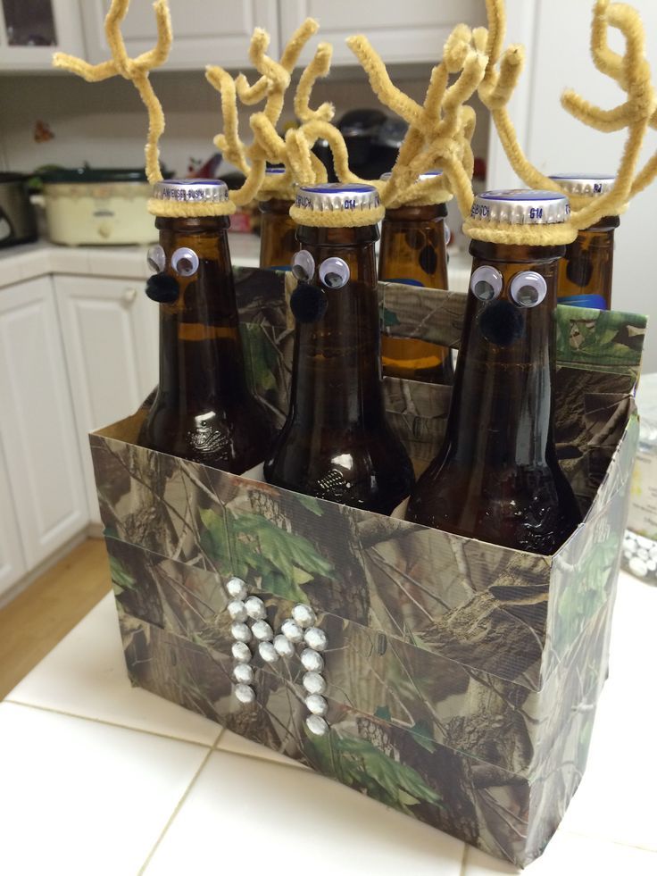 four beer bottles with fake antlers on them sitting in a cardboard box filled with beer