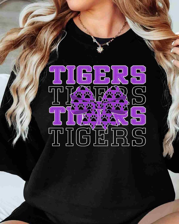 Looking for a fun and unique way to show off your Tigers spirit? Look no further than our Tigers DTF Transfer! This transfer is perfect for creating your own custom t-shirts, hoodies, and more. With our high-quality DTF transfer process, you can expect vibrant, full-color designs that will stand the test of time. This transfer features the Tigers DTF transfer in a bold and eye-catching coquette bow design. Our transfers are incredibly easy to apply using a standard heat press. Whether you're a s Black T-shirt With Lettering For Fan Merchandise, Black Graphic Print Sublimation Design For College, Black Slogan Tops For Fan Merchandise, Black Fan Apparel T-shirt With Lettering, Black Band Merch Sweatshirt With Slogan, Black Cotton Sublimation Design For Game Day, Black Tops With Team Spirit Lettering, Black Screen Print Sweatshirt For Fan Merchandise, Black Fan Apparel Sweatshirt With Graphic Print