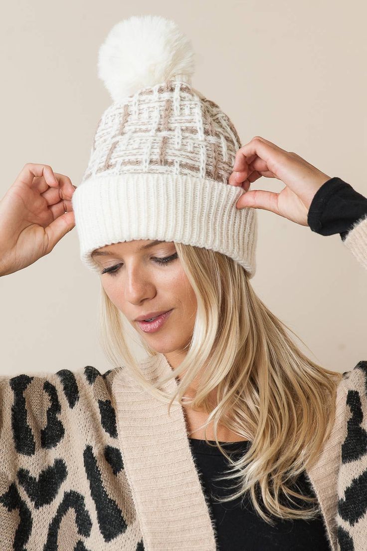 a blonde woman wearing a white hat with a pom - pom on it