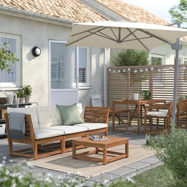 a patio with an umbrella and wooden furniture